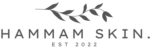 A minimalist brand logo for HAMMAM SKIN. featuring a dark gray leafy branch above the text 'HAMMAM SKIN.